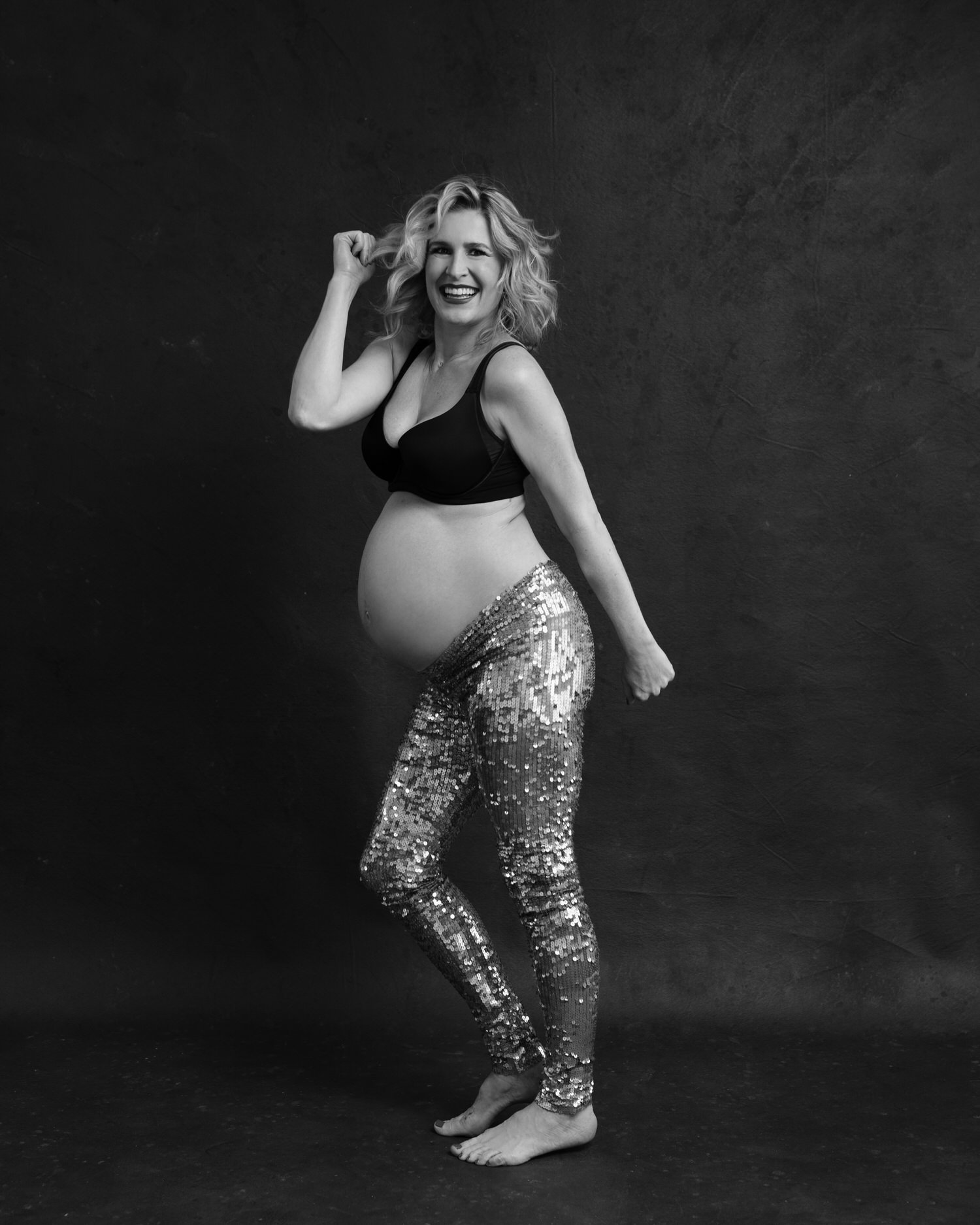 Happy pregnant woman dancing in Toronto photography studio.