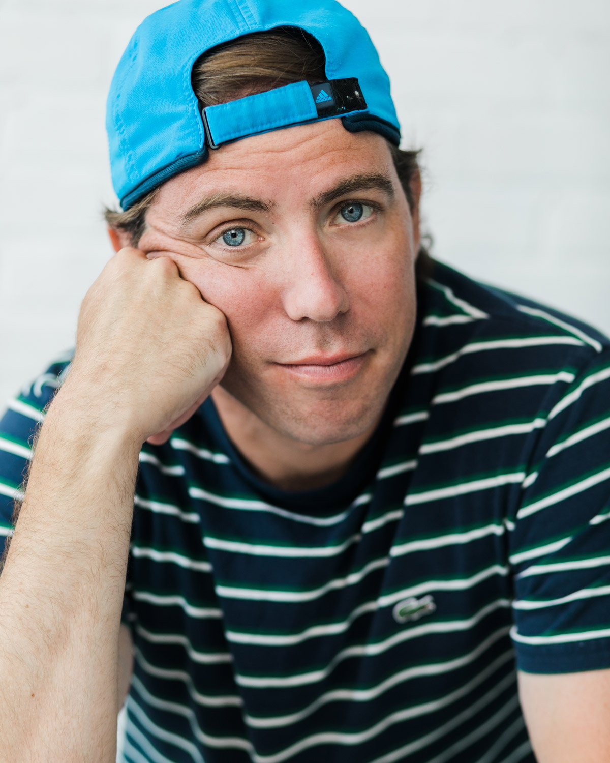 Photo of a man wearing a blue baseball cap.