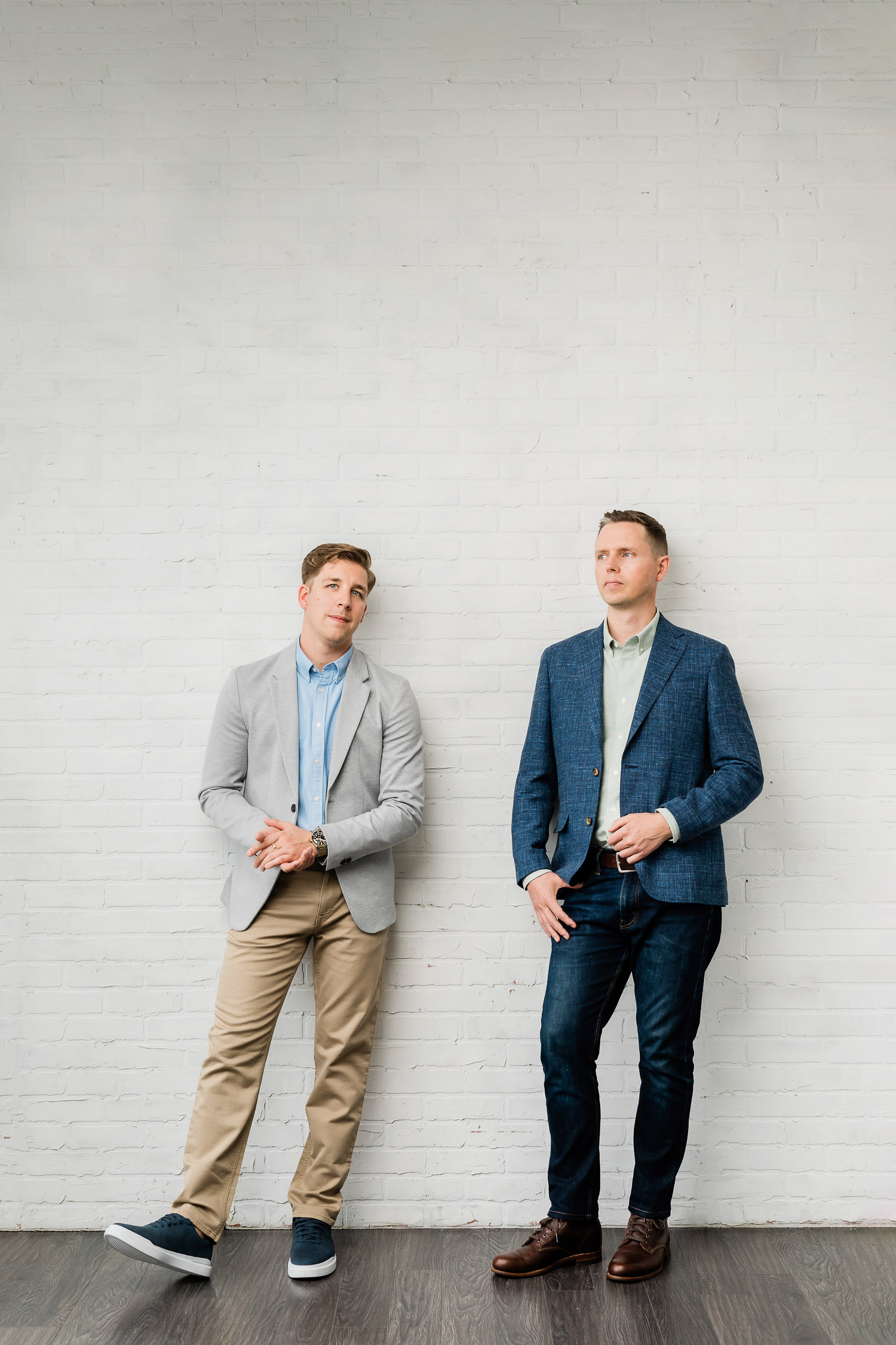 Two architects posing agains a wall for a brand session