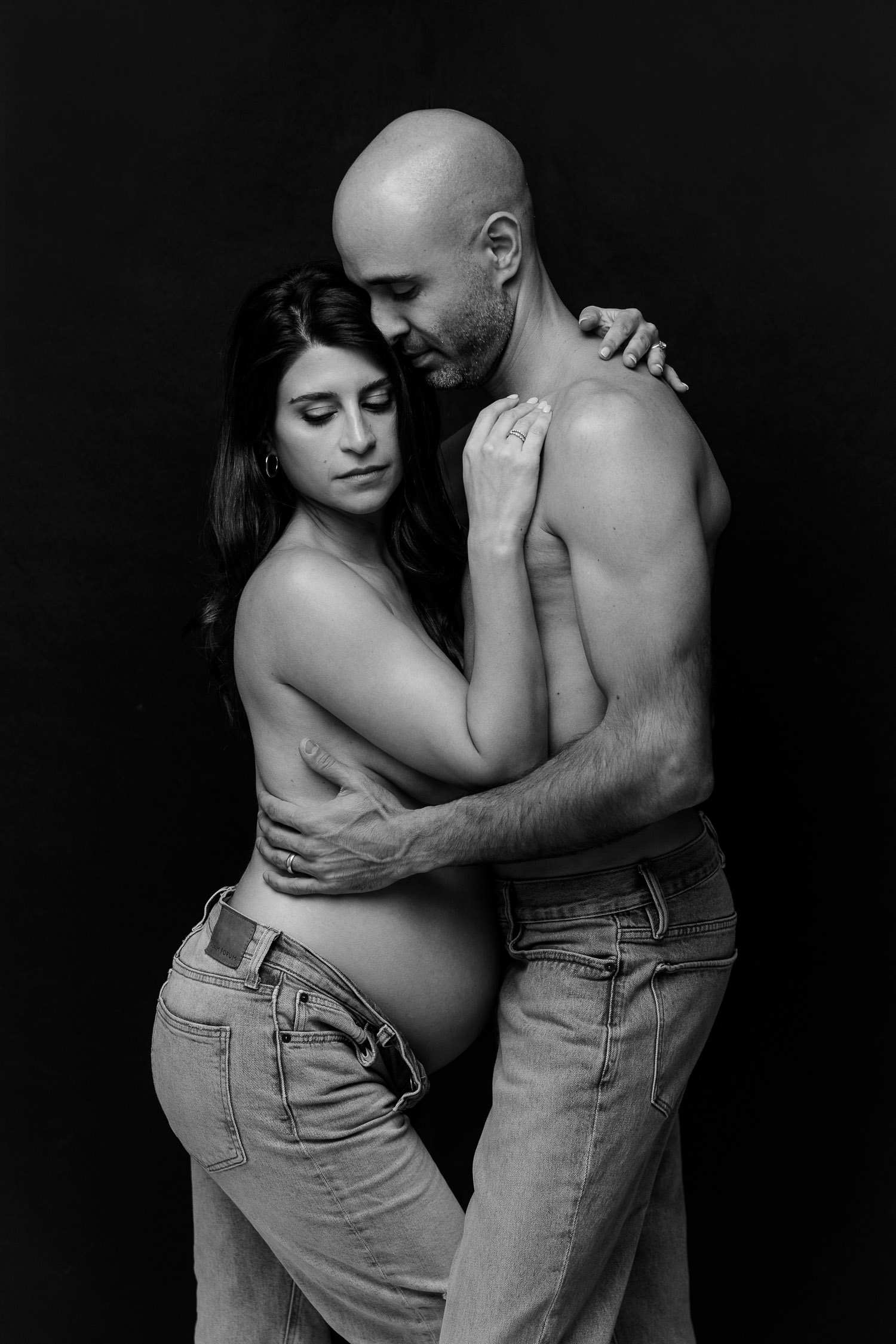 Couple posing like Calvin Klein Models for a maternity photoshoot