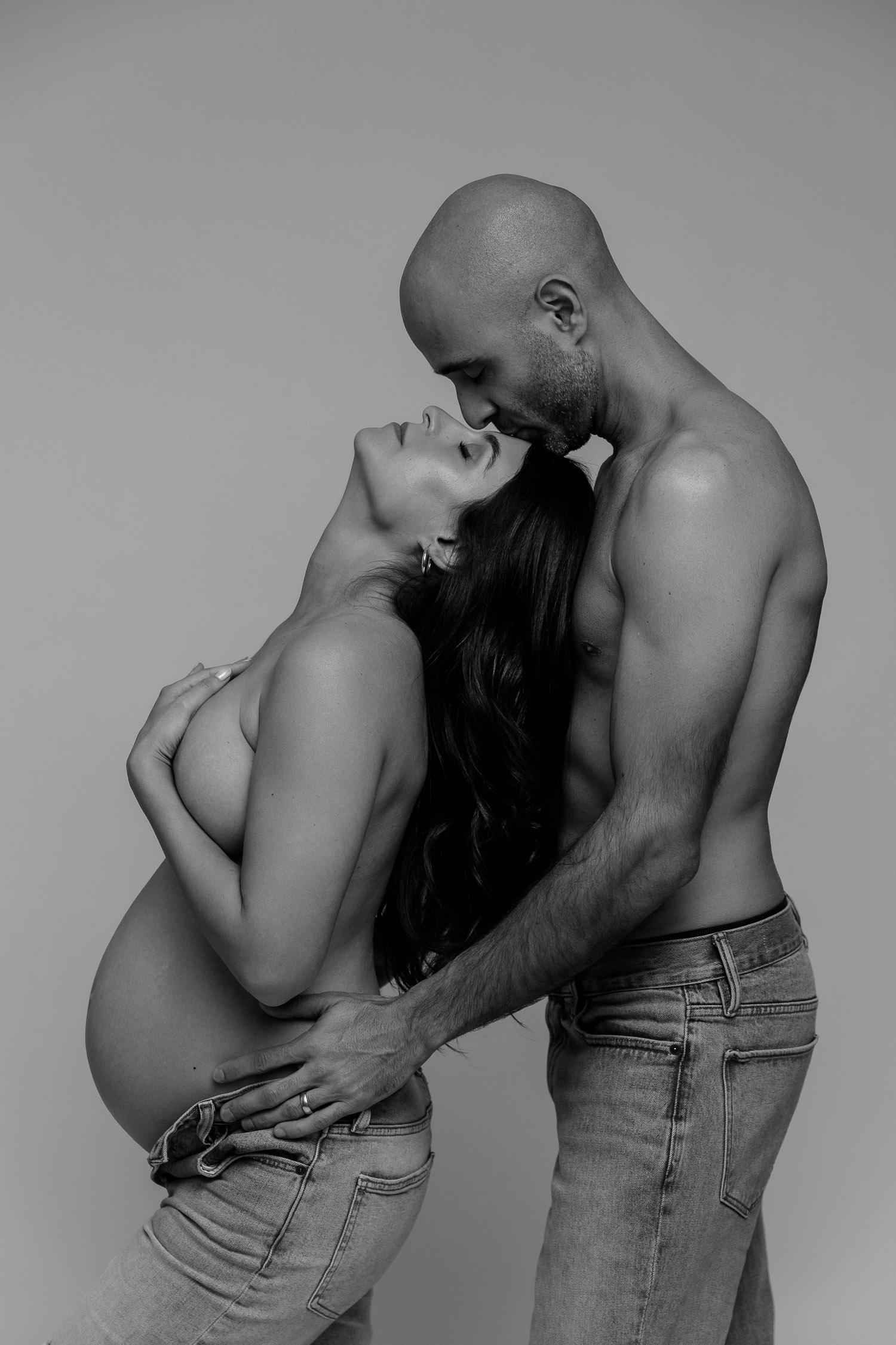 Couple posing like Calvin Klein Models for a maternity photoshoot