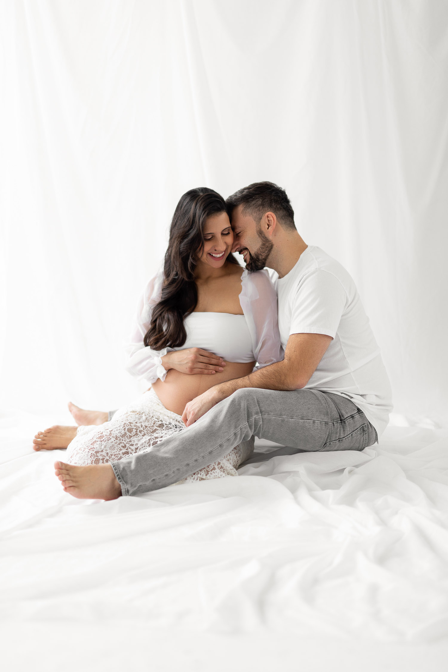 Couple posing for a maternity session in studio